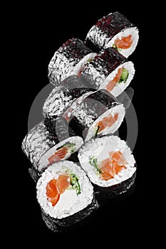 futomaki sushi roll with cucumber salmon cream cheese on a black mirror background