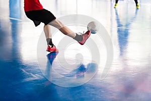 Futsal player shoot ball to goal. Indoor soccer sports hall. Foo