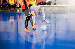 Futsal player trap and control the ball for shoot to goal. Soccer players fighting each other by kicking the ball. Indoor soccer