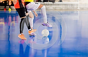 Futsal player trap and control the ball for shoot to goal. Soccer players fighting each other by kicking the ball. Indoor soccer