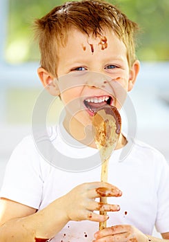 The future of the culinary arts. A little boy covered in dough and flour.