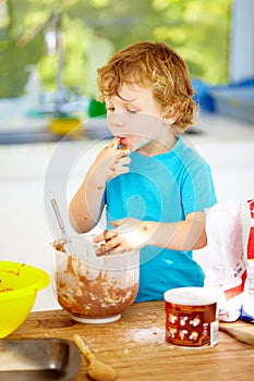 The future of the culinary arts. A little boy covered in dough and flour.