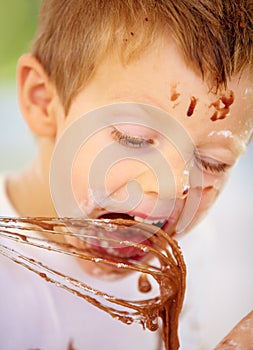 The future of the culinary arts. A little boy covered in dough and flour.