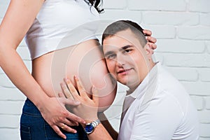 Future dad listens tenderly pregnant tummy. Happy family.