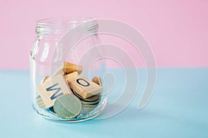 The future of Finance, business banking and financial concept. Flatlay Euro cents and cubic letters inside glass jar on two color