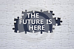 The future is here symbol. Concept words The future is here on white puzzle. Beautiful black background. Business and The future