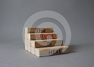 The future is here symbol. Concept words TThe future is here on wooden blocks. Beautiful grey background. Business and The future photo