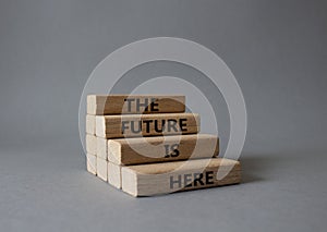 The future is here symbol. Concept words TThe future is here on wooden blocks. Beautiful grey background. Business and The future photo
