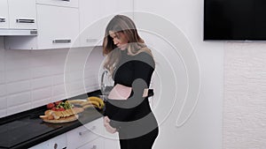Future mother using a belly support belt to avoid back pain