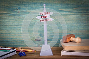 Future, past, present. Signpost on wooden table