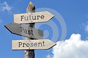 Future, past, present - wooden signpost with three arrows