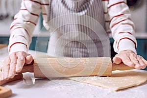Close up of female rolling out dough