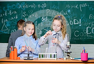 Future technology and science concept. Kids in classroom with microscope and test tubes. Children study biology or