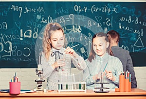 Future technology and science concept. Kids in classroom with microscope and test tubes. Children study biology or