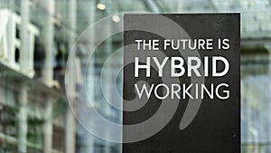 The Future of Work is Hybrid sign in front of a modern office building photo