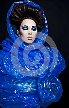 Futuristic beautiful young female face with blue fashion make-up.