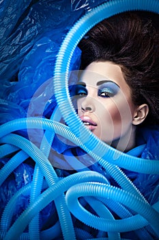 Futuristic beautiful young female face with blue fashion make-up.