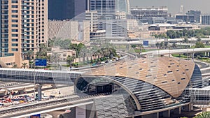 Futuristic building of Dubai metro station and luxury skyscrapers behind in Dubai Marina aerial timelapse, United Arab