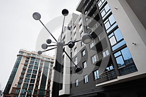 Futuristic lantern against modern residential multistory apartment buildings. Facade of new houses