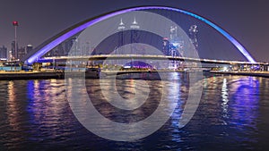 Futuristic Pedestrian Bridge over the Dubai Water Canal Illuminated at Night timelapse, UAE.