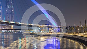 Futuristic Pedestrian Bridge over the Dubai Water Canal Illuminated at Night , UAE.