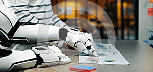 Futuristic Robot Collaborating with Human in Office Environment Analyzing Graphs and Charts on Desk for Innovative