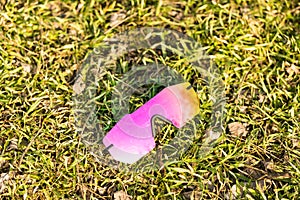 Futuristic sunglasses model rimless with big pink lens reflecting the sun in a summer day closeup. Selective focus