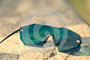 Futuristic sunglasses model rimless with pink lenses reflecting the sun in a summer day shoot outside closeup. Selective