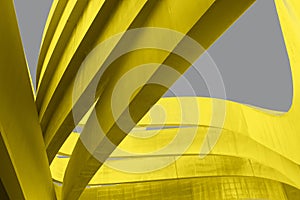 Futuristic urban backdrop. Art arch triangles made of metal in yellow color on grey background. Textured Bright yellow