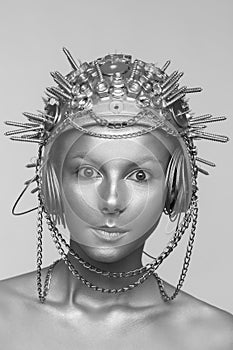 Futuristic woman in metal helmet with screws, nuts and chains