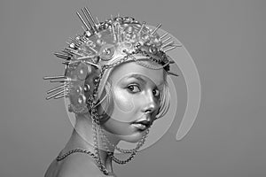 Futuristic woman in metal helmet with screws, nuts and chains