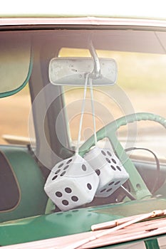 Fuzzy Dice Hanging from the Rearview Mirror of an Antique Car