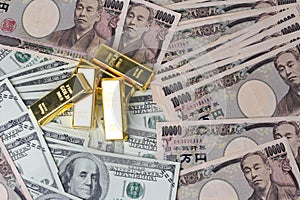 5 of  999.9 % of 1000 g Gold bars  placed on dallar banknotes  and Yen bank notes