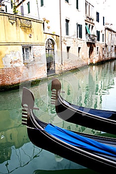GÃ³ndolas at venetian canal on quiet water photo