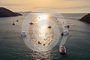 G\roup of private yacht sailing on tropical sea at the sunset