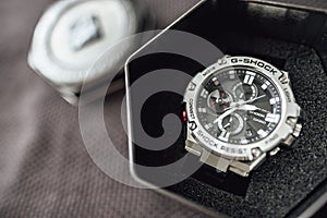 A G-SHOCK GST-B100 with box on grey background