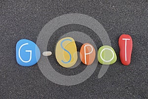 G-Spot, erogenous zone emblem text composed with multi colored stones over black volcanic sand