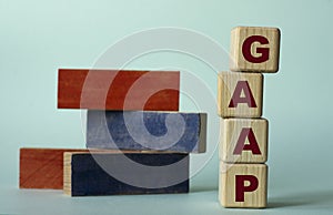 GAAP - acronym on wooden cubes on a background of colored block on a light background