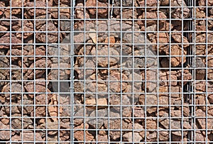 Gabion wall filled with lava stones photo