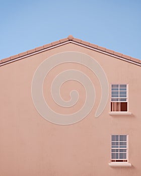 Gable house front view with pink wall and blue sky.Minimal concept.