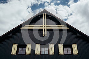 Gable roof of ancient cottage with cloudy sky