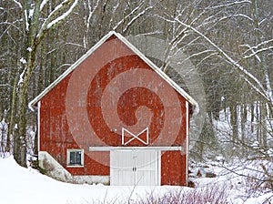 Gable roof closeup of red barn in winter snowstorm