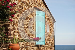 Gable of stone-clad house featuring sea visible in background, Collioure, France