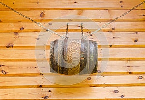 Gable of wooden rural house and barrel with chains