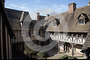 gabled roof and half-timbering of tudor house, with view toward courtyard