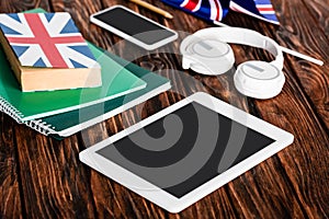 Gadgets near copybooks and book with uk flag