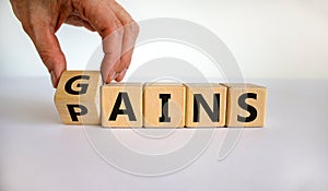 Gains and pains symbol. Businessman turns wooden cubes, changes word pains to gains. Beautiful white background. Business, pains