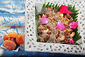 gajar ka halwa.gajorer halua. gajrela, gajar pak, and carrot halwa in a decorative bowl with rose petals and cashew nuts.