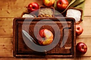 Gala apple with old pairing knife on wood cutting board