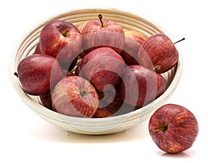 Gala apples in rattan bowl isolated on white background